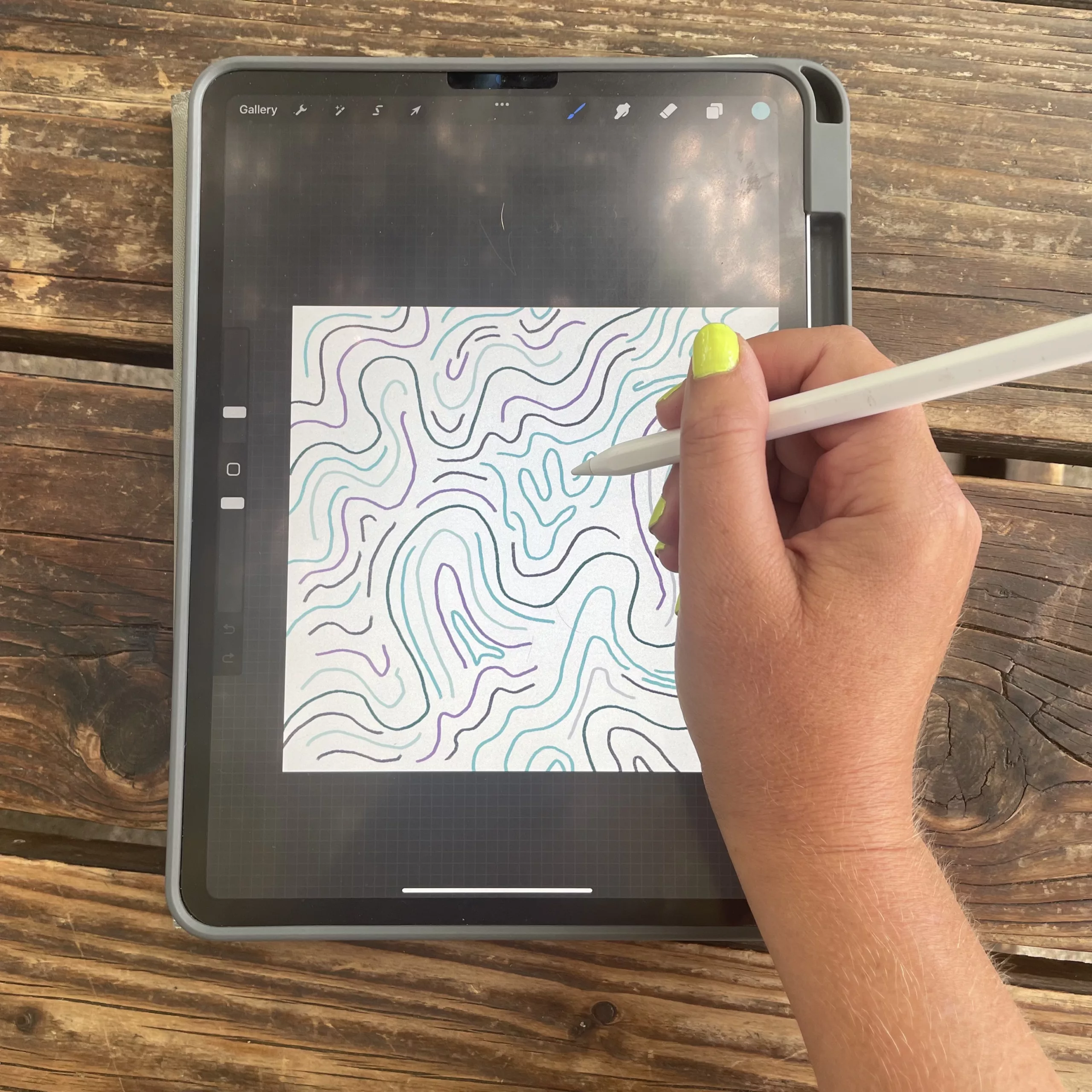 A hand draws a bunch of squiggles in the ipad program Procreate